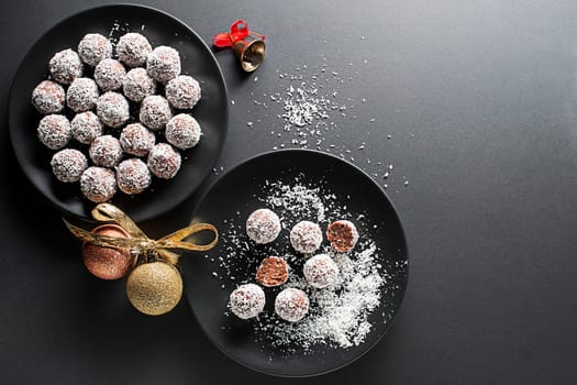 Delicious Coconut-Chocolate balls covered with grated coconut. Soft, delicious and fudgy coconut balls with rum, biscuit and chocolate. Traditional Christmas cookies concept