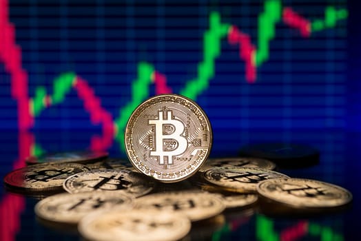 Bitcoin and cryptocurrency investing concept with graph. Bitcoin cryptocurrency coins. Trading on the cryptocurrency exchange. Trends in bitcoin exchange rates. Rise and fall charts of bitcoin.