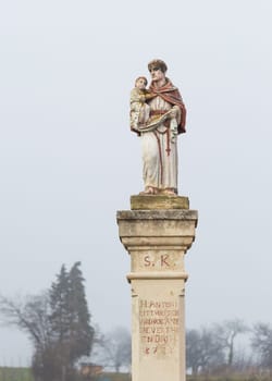 Statue with saint holding baby jesus on a waycross in Burgenland