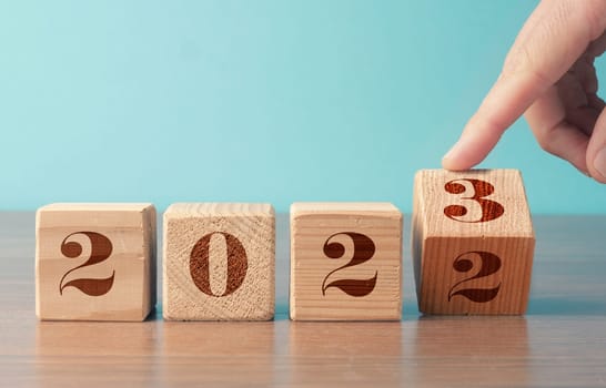 Flipping wooden cubes with the Year number 2022 and 2023, New Year concept, seasonal Christmas time