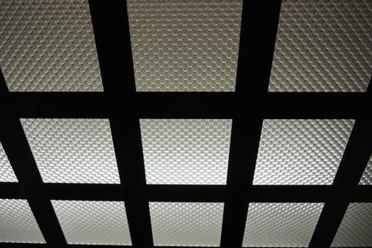 Electric LED light in the elevator. The ceiling of the elevator car. Checkered light source, horizontal and vertical metal lines and corrugated glass. Equipment for a modern elevator in new building