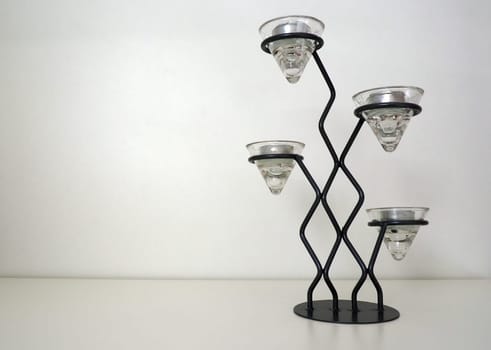 Tall metal modern chandelier with glass holders for small candles in aluminum package. Place for text. White background. Copy space.
