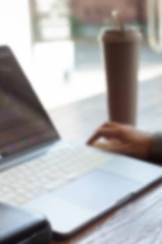 Woman working with a laptop blur background, stock photo