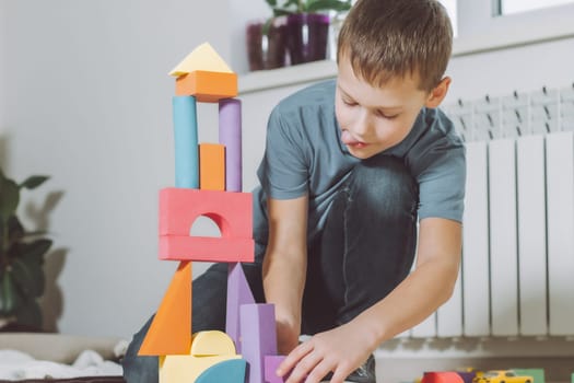 7-10 boy playing at home on the floor with geometric shapes constructor