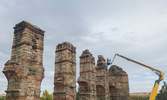 Telescopic boom working at Roman Aqueduct Los Milagros, Merida, Spain. Ancient architecture preserving works concept