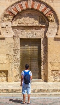 Tourist faces to exterior door of Great Cordoba Mosque, Andalusia, Spain