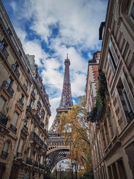 Eiffel tower as seen through the parisian buildings. Snenery autumn season in Paris, France...