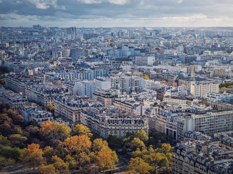 Paris cityscape view from the Eiffel tower height, France. Fall season scene with colored trees