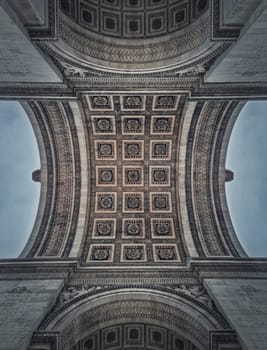 Closeup view underneath triumphal Arch, in Paris, France. Architectural details and ceiling ornate pattern of the famous Arc de triomphe landmark.