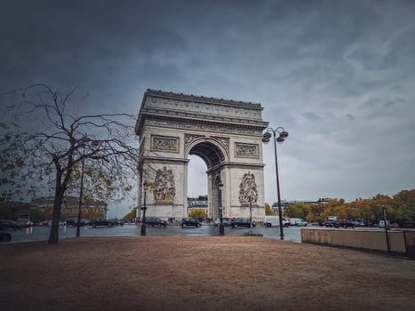 Arc de triomphe in Paris, France. Rainy autumn day with a romantic view to the triumphal arch landmark from avenue