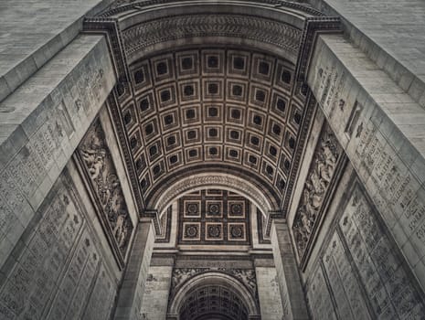 View underneath triumphal Arch, in Paris, France. Architectural details of the famous Arc de triomphe landmark.