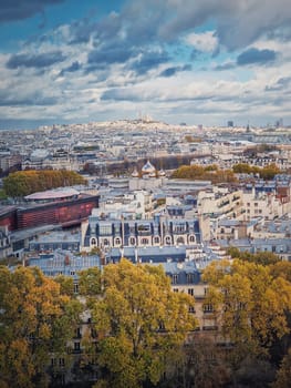 Aerial view over the Paris city to the Sacre Coeur de Montmartre basilica on the hill, France. Autumn parisian cityscape, vertical background