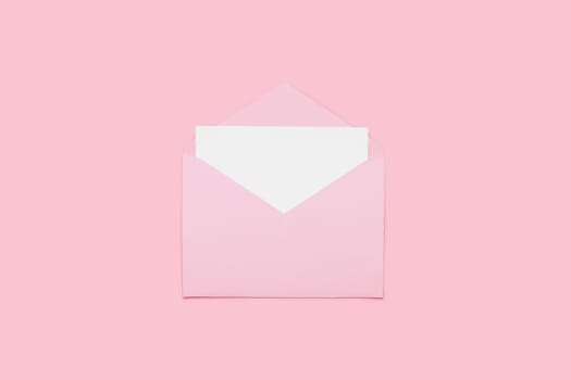 Closeup on blank empty white paper card in pink opened envelope isolated on pink pastel color background. Love letter minimal concept. Conceptual layout template with text place on postcard. Mock-up