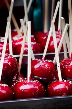 Red candy apple on holiday fair market closeup. Traditional sweet glazed apples for halloween treats.