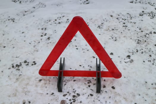red warning triangle on winter road, danger concept