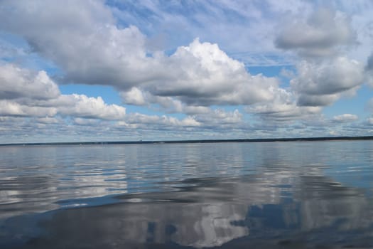 celestial landscape cumulus clouds reflected in blue sea water