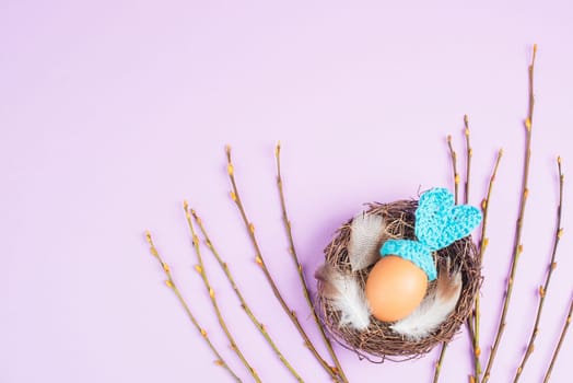Easter bunny or rabbit in a bird nest, made from an egg and crocheted ears, spring holiday, greeting card