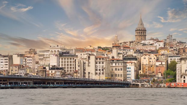 Istanbul, Turkey - August 25, 2022: City skyline including Galata Bridge with traditional fish restaurants in the passage under the bridge, and Galata Tower in the far end