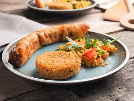 Tasty Falafel with spicy bulgur and a vegetarian dough roll on a ceramic plate, traditional heatlhy food