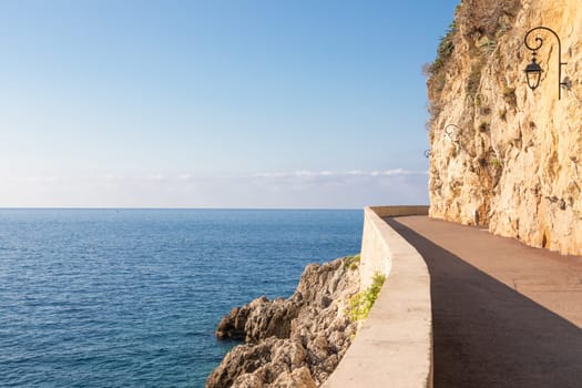 Promenade in front of the sea. Blue sky on scenery seascape. Concept of travel, adventure, freedom