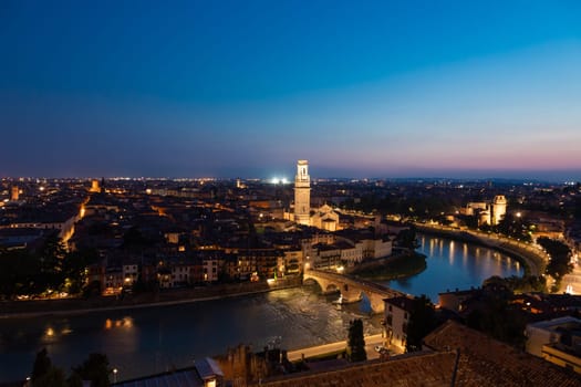Verona, Italy - June 2022: panorama by night. Illuminated cityscape with scenic bridge