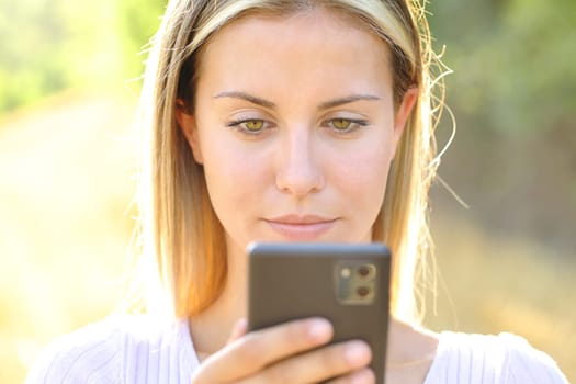 Front view portrait of a teen using smart phone in nature