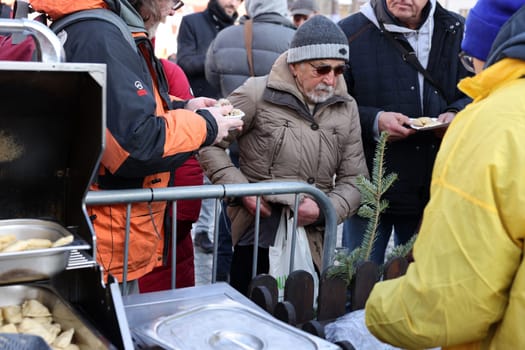 Krakow, Poland - Dec 18, 2022: Christmas Eve for poor and homeless on the Main Square in Cracow. The group Kosciuszko prepares the greatest eve in the open air in Krakow