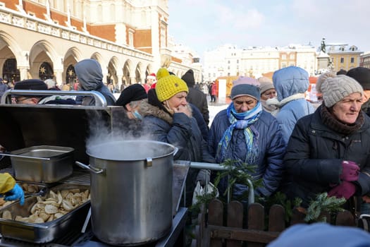 Krakow, Poland - Dec 18, 2022: Christmas Eve for poor and homeless on the Main Square in Cracow. The group Kosciuszko prepares the greatest eve in the open air in Krakow