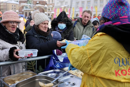 Krakow, Poland - Dec 18, 2022: Christmas Eve for poor and homeless on the Main Square in Cracow. The group Kosciuszko prepares the greatest eve in the open air in Krakow