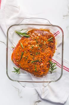 Classic marinated beef flank steak in bowl on white kitchen table