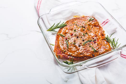 Classic marinated beef flank steak in bowl on white kitchen table