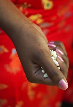 A black girl getting ready to  greet the newly wedded couple with some rice.