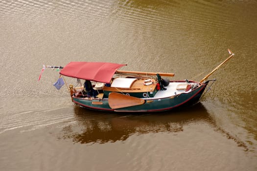 The replica of an old Chinese boat,a junk in a harbour water.