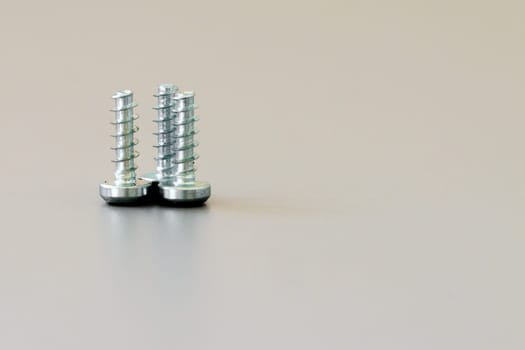 A close up of three threaded screws standing side by side
