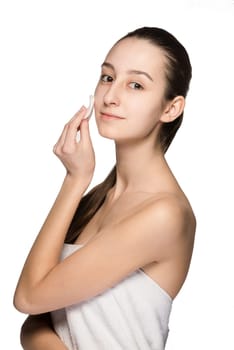 skin care woman removing face with cotton swab pad - skin care concept. Facial closeup of beautiful Caucasian model with perfect skin. Girl isolated on white background