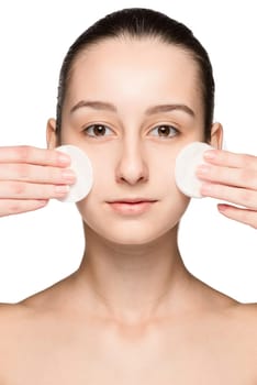 skin care woman removing face with cotton swabs - skin care concept. Facial closeup of beautiful Caucasian model with perfect skin. Girl isolated on white background