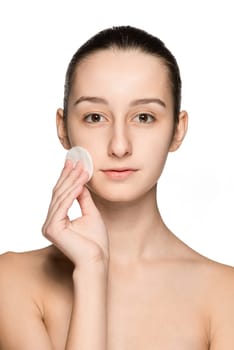 skin care woman removing face with cotton swab pad - skin care concept. Facial closeup of beautiful Caucasian model with perfect skin. Girl isolated on white background