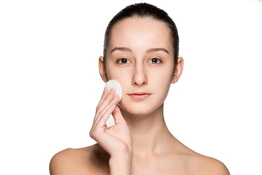 skin care woman removing face with cotton swab pad - skin care concept. Facial closeup of beautiful Caucasian model with perfect skin. Girl isolated on white background