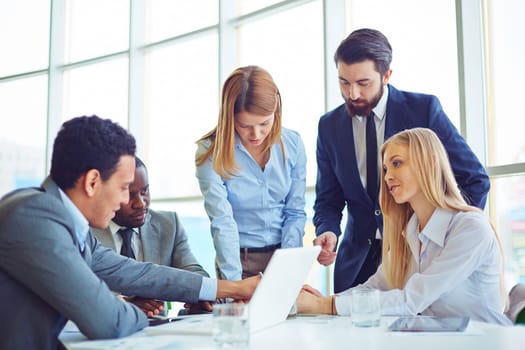 Group of employees discussing ideas and planning work in office