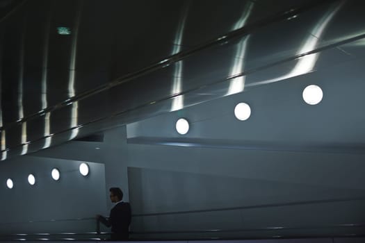 Elegant man descending on escalator after work