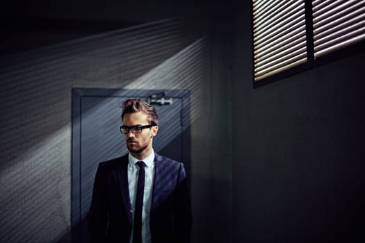 Businessman in suit standing by the door in office building