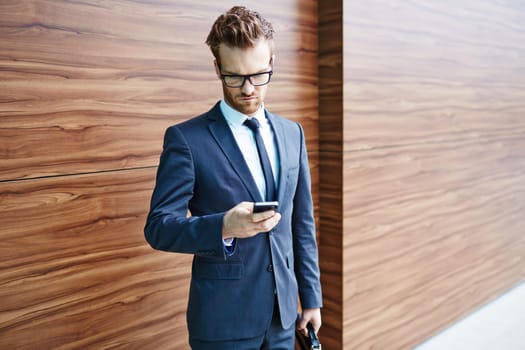 Businessman in suit and eyeglasses using cellphone