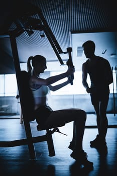 Fit young woman exercising on facilities in gym