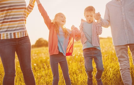 Happy family walking on the field on summertime. Conceptof love, relationship between people and vacation together.