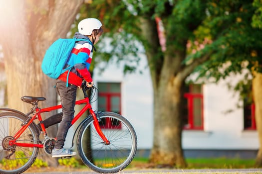 Teenager in the morning quickly riding on bicycle to the lesson. Concept of the back to school.