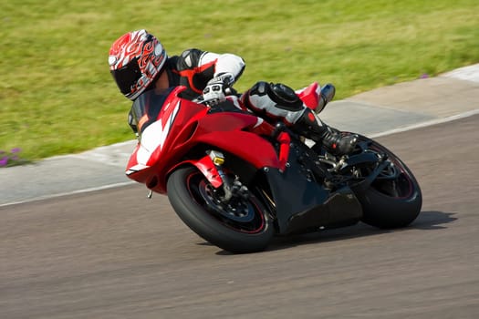 Motorbike racing on the track in Summer.
