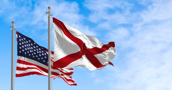 The flag of the state of Alabama waving alongside the national flag of the United States on a sunny day. The flag of Alabama features a red cross on a white field. Realistic 3d illustration