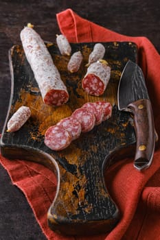Fermented salami sausages on wooden cutting board cut on slices