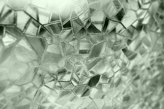Corrugated glass green background. Abstract pattern on the surface of a window. Protective opaque film