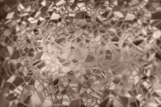 Embossed glass background. Corrugated glass sepia monochrome. Refraction of light in a bumpy transparent surface under backlight. The play of highlights. Black brown areas. Abstract background.